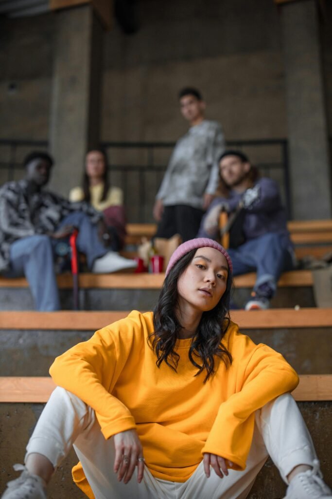 Group of diverse young adults in stylish attire, posing indoors with a modern vibe.